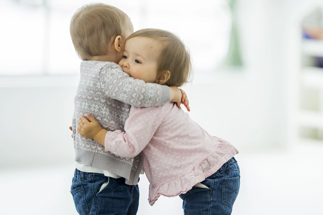 Zwei Kleinkinder umarmen sich.