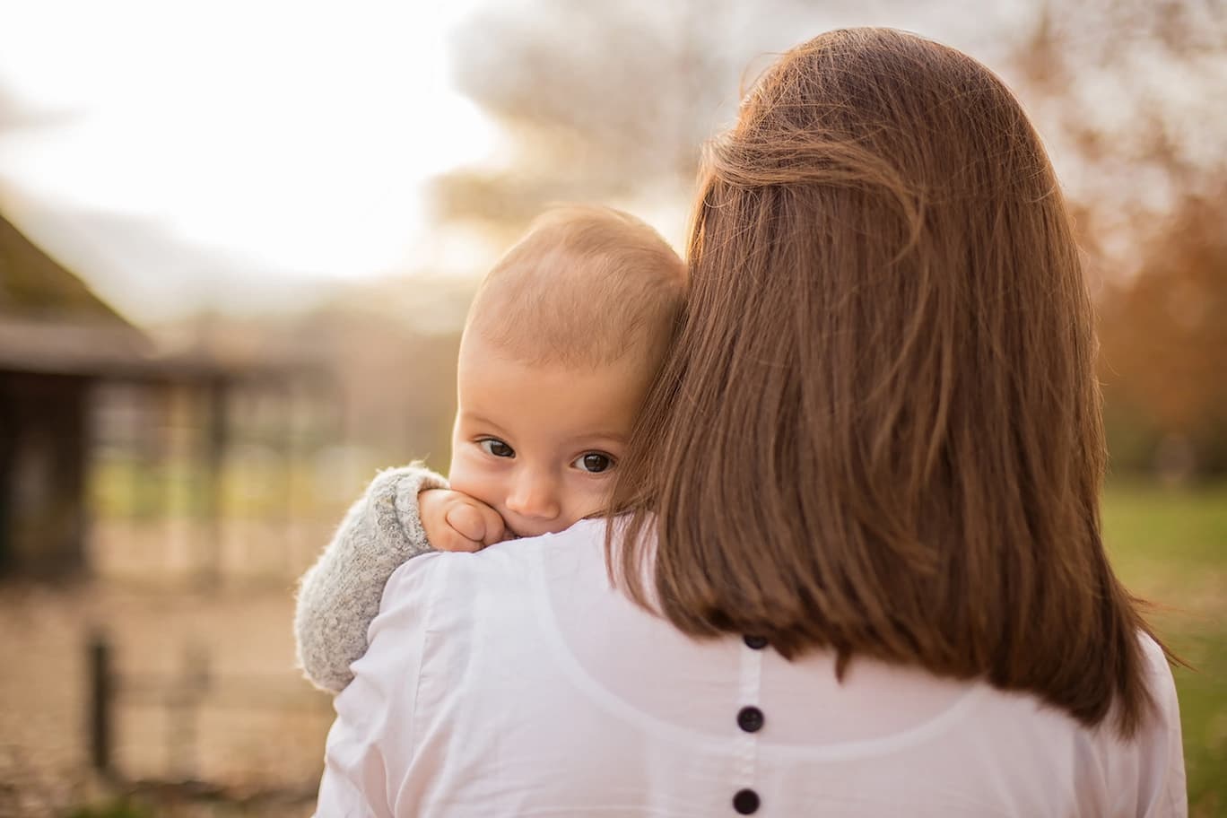 Baby schaut über die Schulter ihrer Mutter