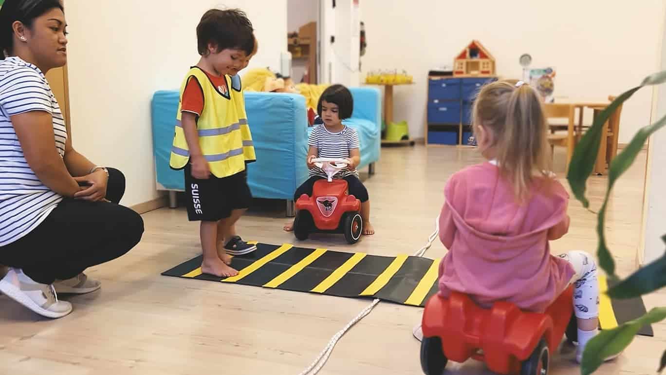 Kinder üben in der Kita das Überqueren der Strasse