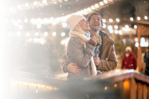 Ein Paar umarmt sich an einem Weihnachtsmarkt.